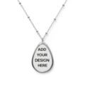 A silver Custom Oval Pendant Necklace featuring a beaded chain and a teardrop-shaped pendant with a white placeholder reading "ADD YOUR DESIGN HERE."