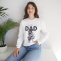A woman wearing a white Super Dad Crewneck Sweatshirt featuring a sentimental illustration of a father kneeling to hug his child.