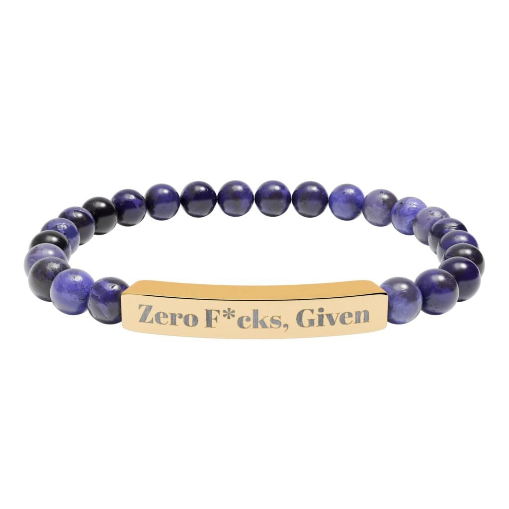 A premium Engraved Natural Stone Bracelet featuring deep purple jasper beads and a gold stainless steel bar engraved with the bold statement "Zero F*cks Given."
